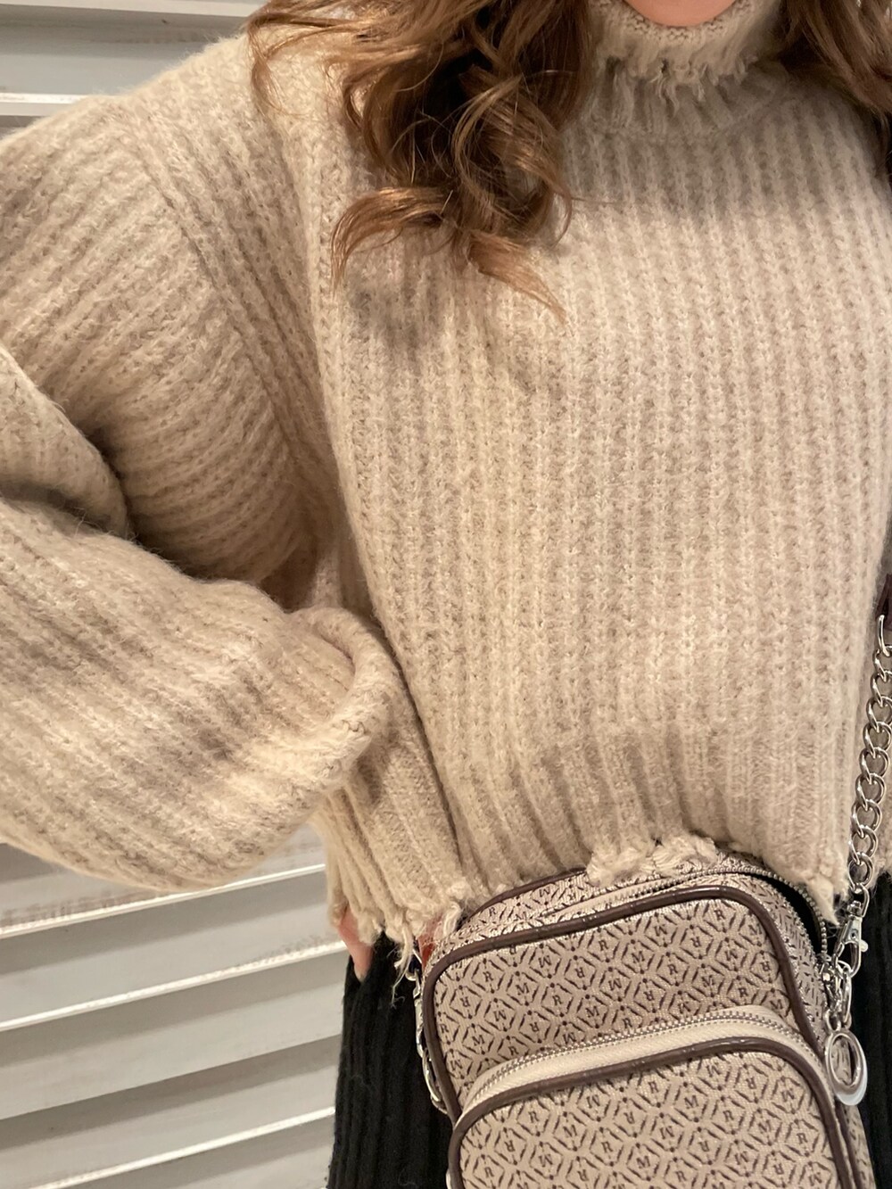 ホワイト系のニット/セーター、ブラック系のブーツ、その他のショルダーバッグを着用したレディースの秋コーディネートの5枚目の写真