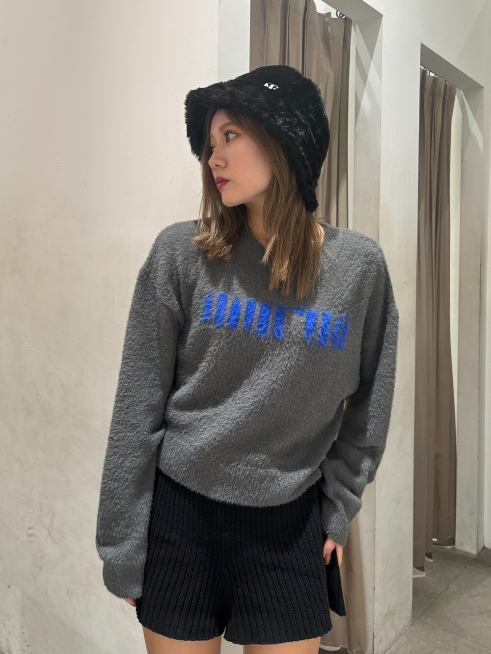 グレー系のニット/セーター、ブラック系のその他パンツ、ブラック系のブーツを着用したレディースの秋コーディネートの8枚目の写真