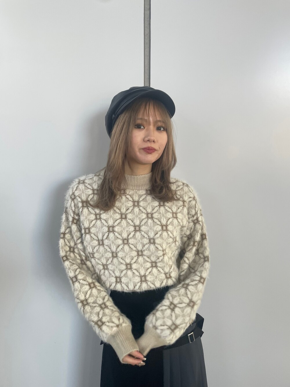 ホワイト系のニット/セーター、ブラック系のスカートを着用したレディースの冬コーディネートの5枚目の写真