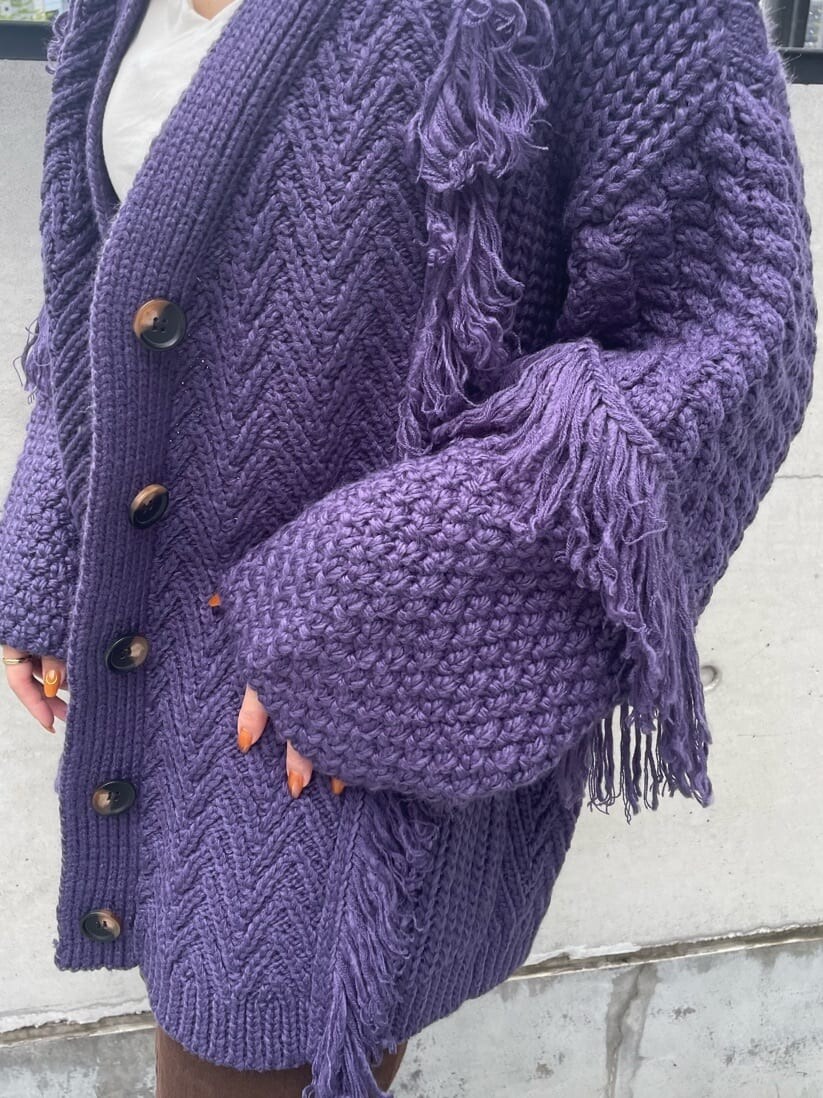 ブラウン系のスカート、ベージュ系のブーツ、パープル系のカーディガン/ボレロを着用したレディースの秋コーディネートの6枚目の写真