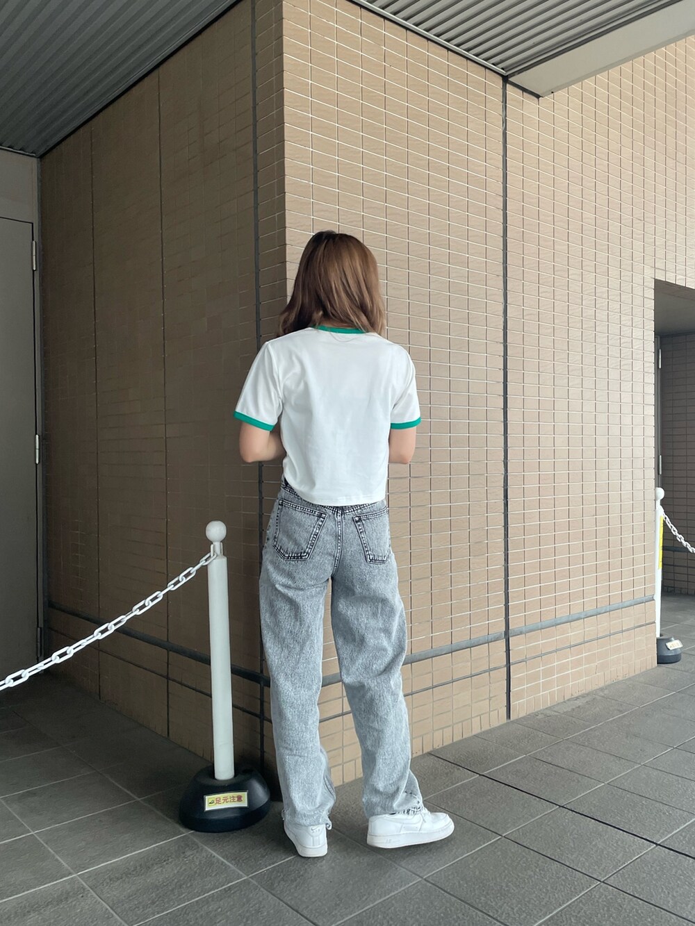 ホワイト系のTシャツ/カットソー、グレー系のデニムパンツを着用したレディースの春コーディネートの4枚目の写真