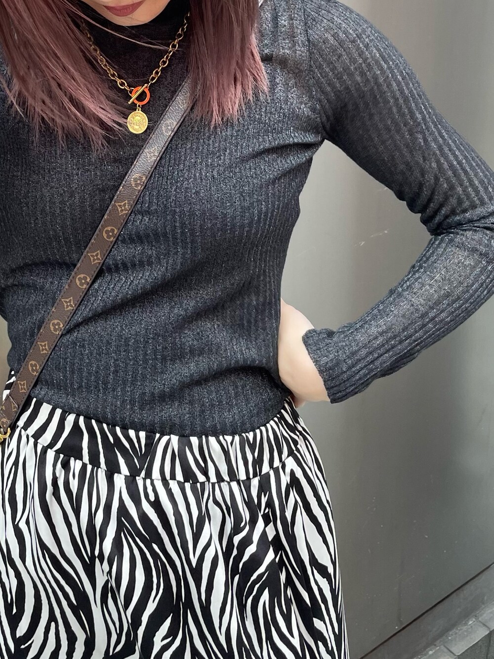 ブラック系のニット/セーター、ホワイト系のスカート、その他のサンダルを着用したレディースの春コーディネートの5枚目の写真