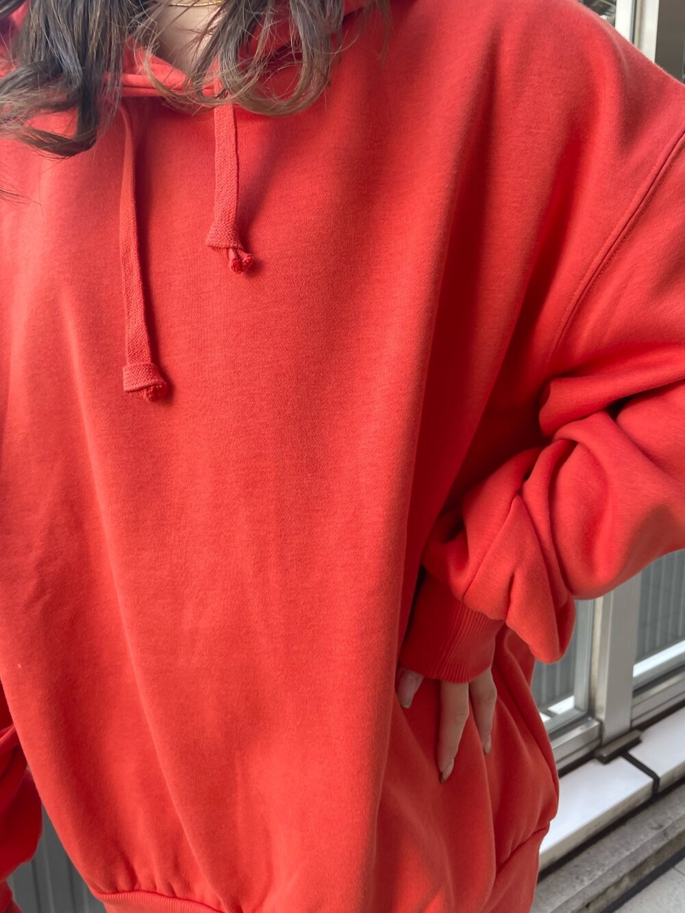 オレンジ系のパーカー、ブラック系のブーツを着用したレディースの秋コーディネートの6枚目の写真