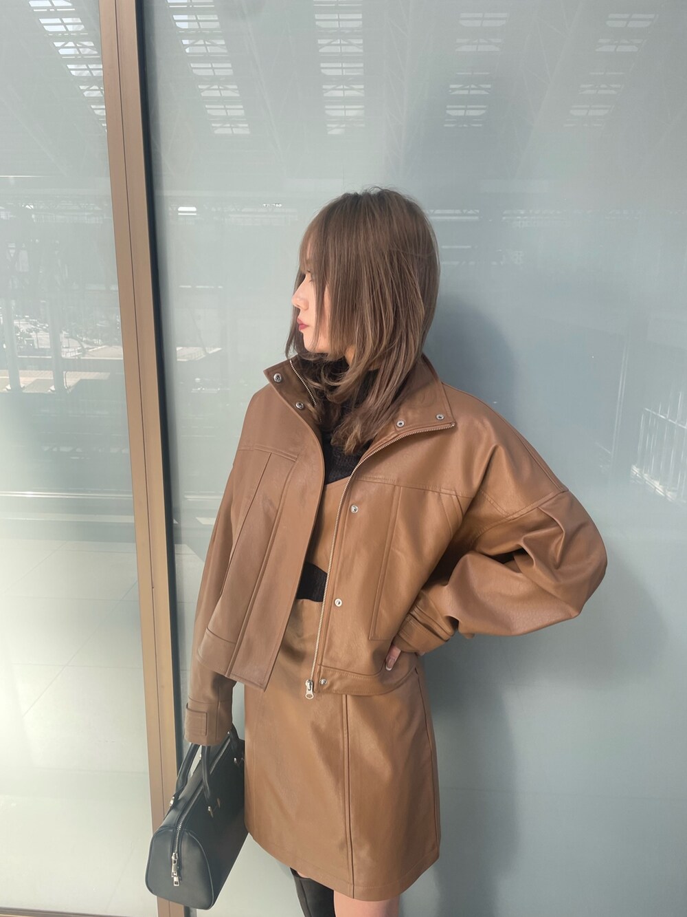 ブラック系のニット/セーター、ブラウン系のワンピース、イエロー系のブルゾンを着用したレディースの冬コーディネートの7枚目の写真