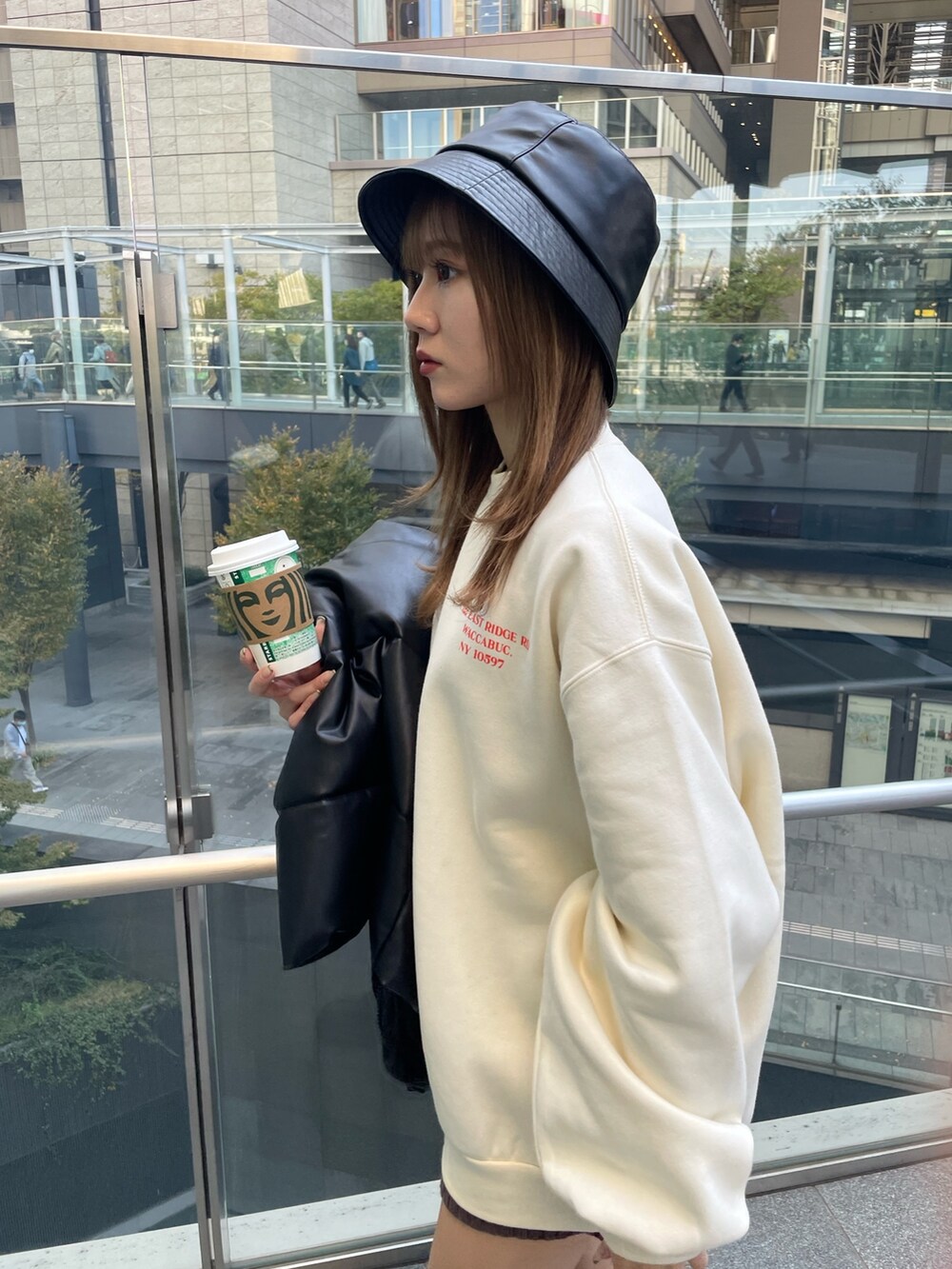 ホワイト系のスウェット、ブラック系のブーツ、ブラック系のハットを着用したレディースの秋コーディネートの7枚目の写真