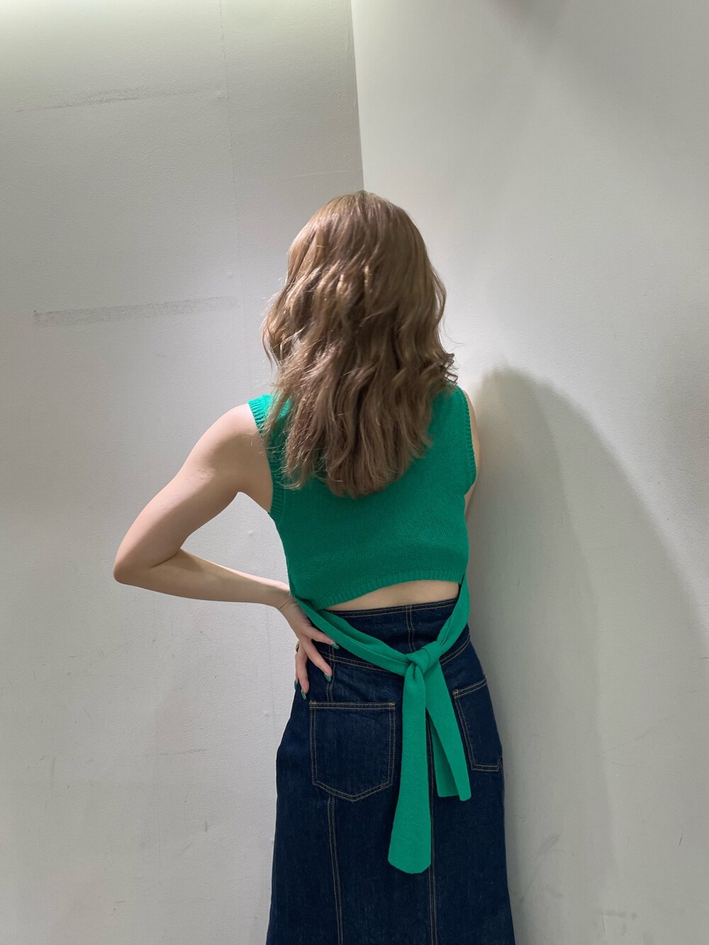 ブラック系のサンダル、ブラック系のショルダーバッグ、グリーン系のタンクトップを着用したレディースの夏コーディネートの6枚目の写真