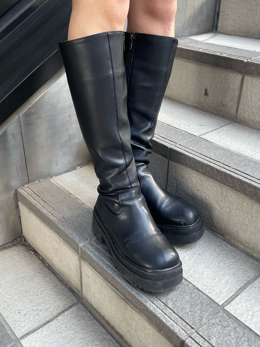 グリーン系のワンピース、ブラック系のブーツ、ベージュ系のハットを着用したレディースの冬コーディネートの7枚目の写真