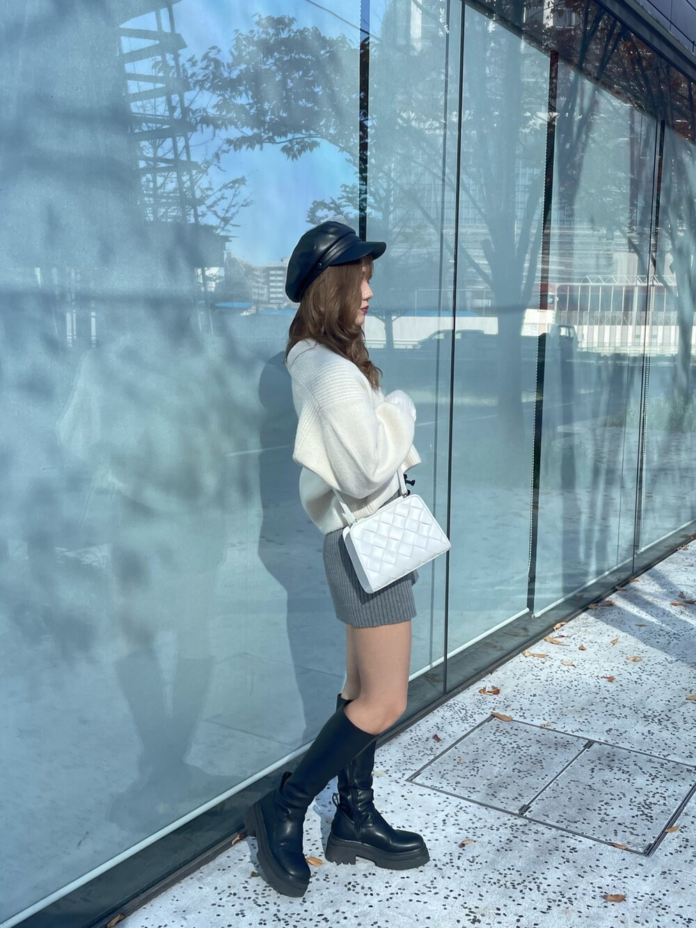 ホワイト系のニット/セーター、グレー系のスウェットパンツ、ブラック系のブーツを着用したレディースの秋コーディネートの2枚目の写真