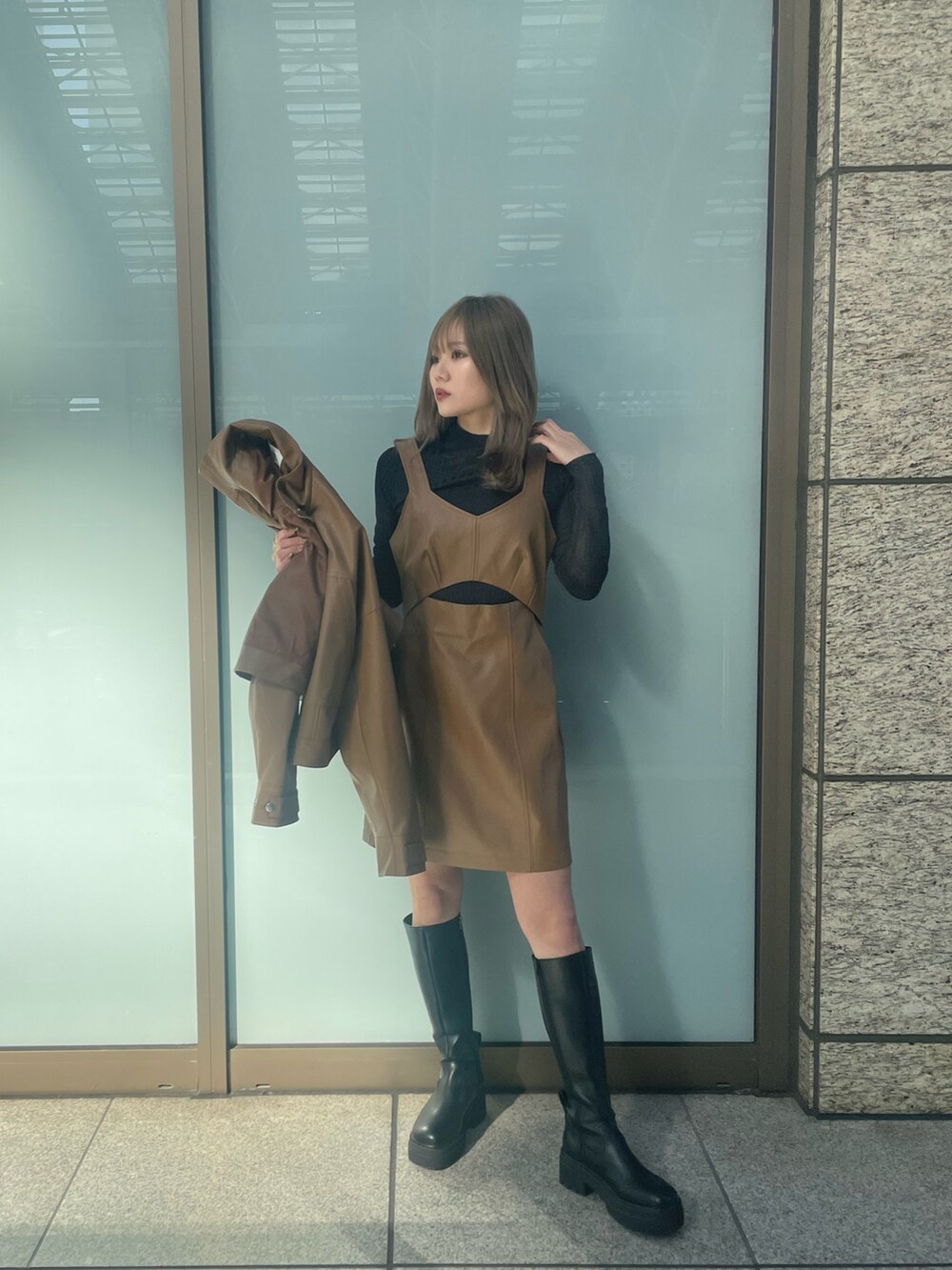 ブラック系のニット/セーター、ブラウン系のワンピース、イエロー系のブルゾンを着用したレディースの冬コーディネートの2枚目の写真