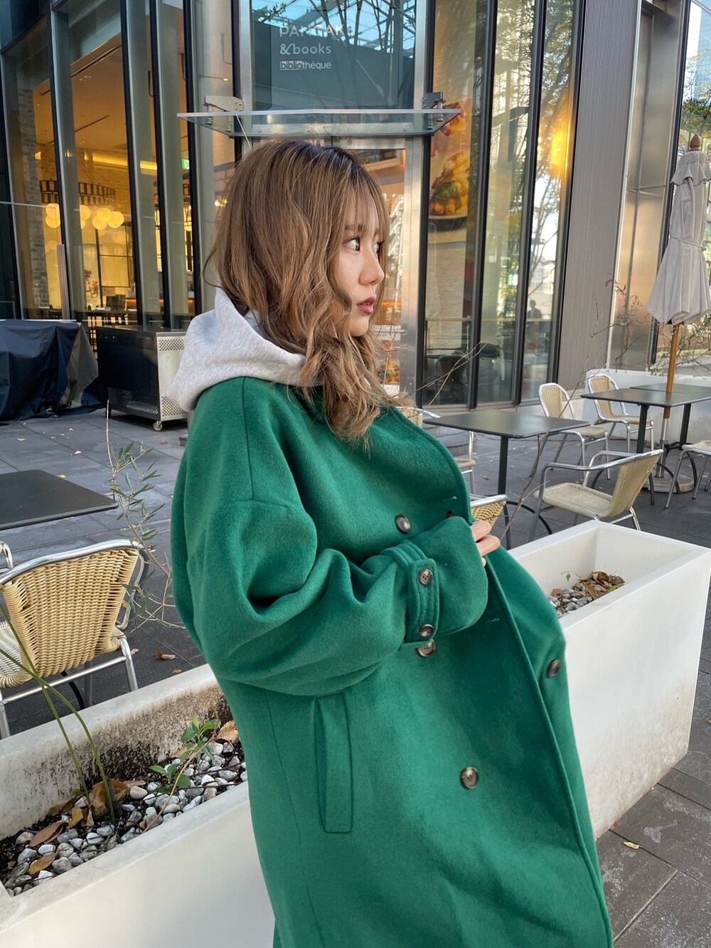 グリーン系のチェスターコート、ブラック系のブーツを着用したレディースの秋コーディネートの4枚目の写真