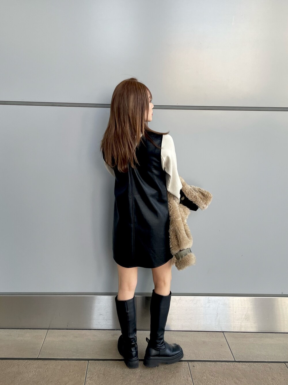 ブラック系のワンピース、ホワイト系のニット/セーター、ブラウン系のムートンコートを着用したレディースの冬コーディネートの8枚目の写真