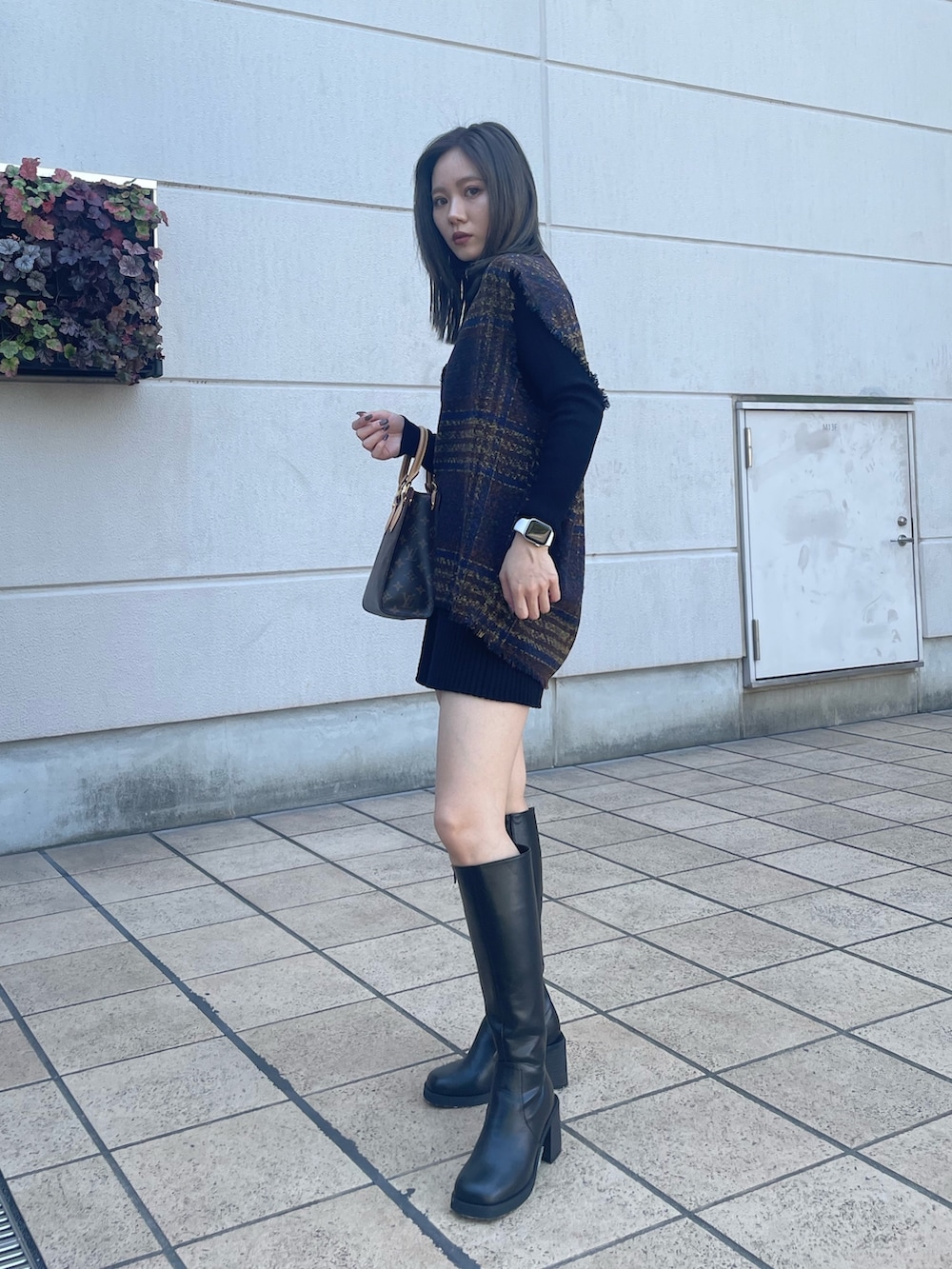 ブラック系のニット/セーター、ブラック系のその他パンツ、ブラウン系のワンピースを着用したレディースの秋コーディネートの2枚目の写真