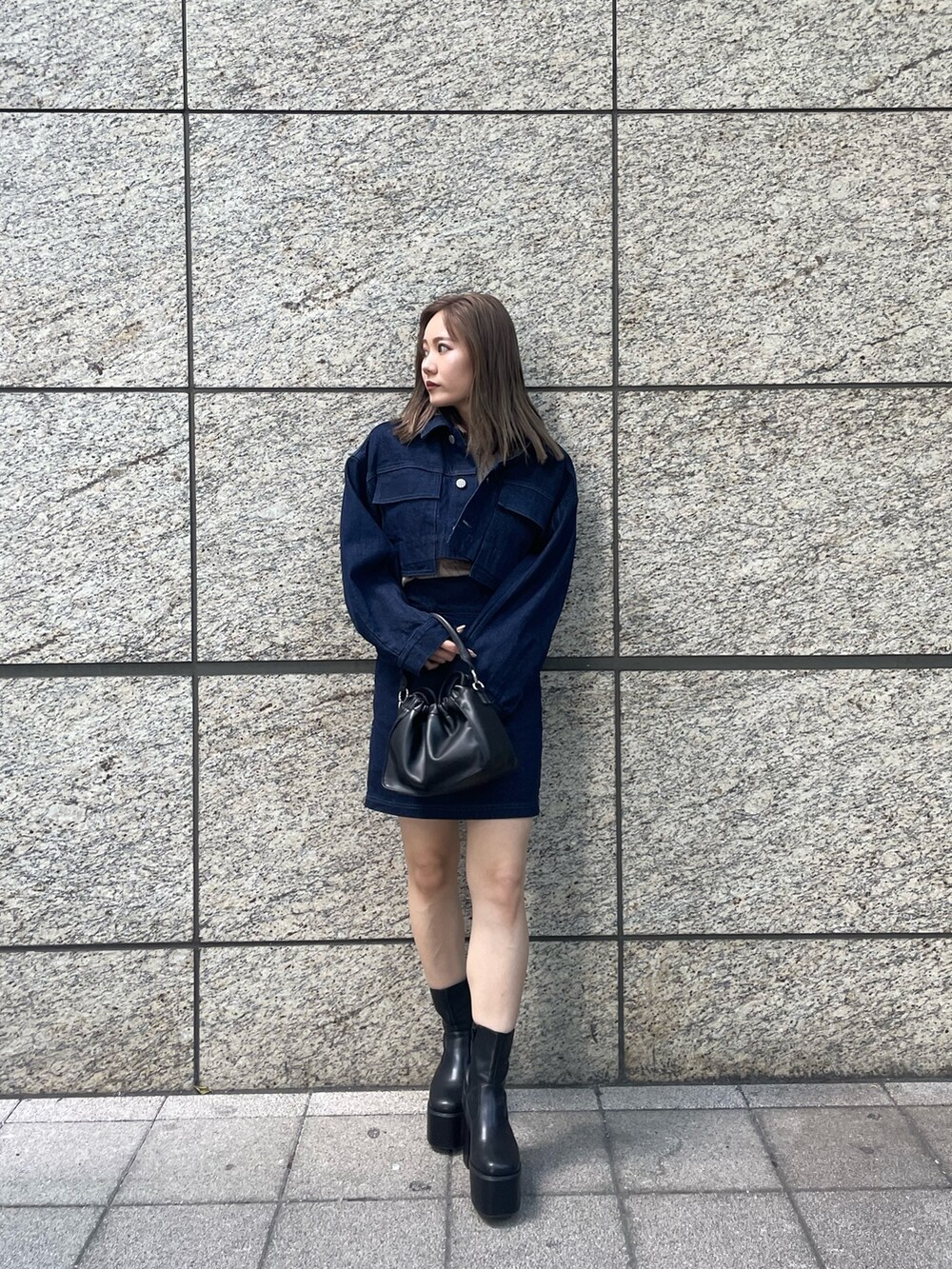 ベージュ系のニット/セーター、ブルー系のスカート、ブラック系のブーツを着用したレディースの夏コーディネートの2枚目の写真