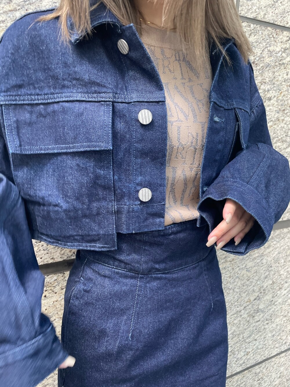 ベージュ系のニット/セーター、ブルー系のスカート、ブラック系のブーツを着用したレディースの夏コーディネートの8枚目の写真