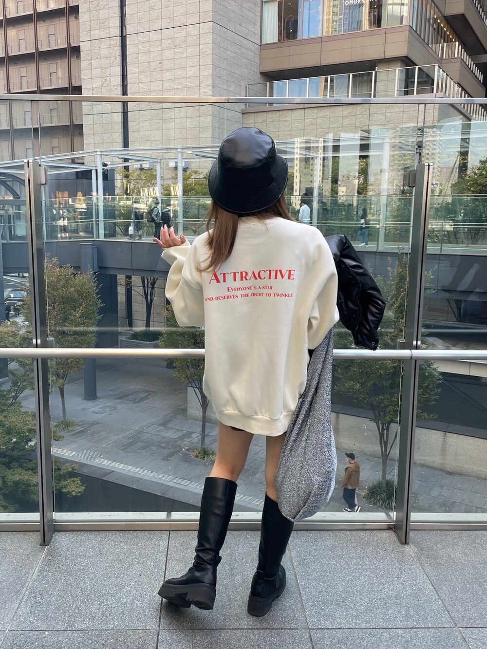 ホワイト系のスウェット、ブラック系のブーツ、ブラック系のハットを着用したレディースの秋コーディネートの2枚目の写真