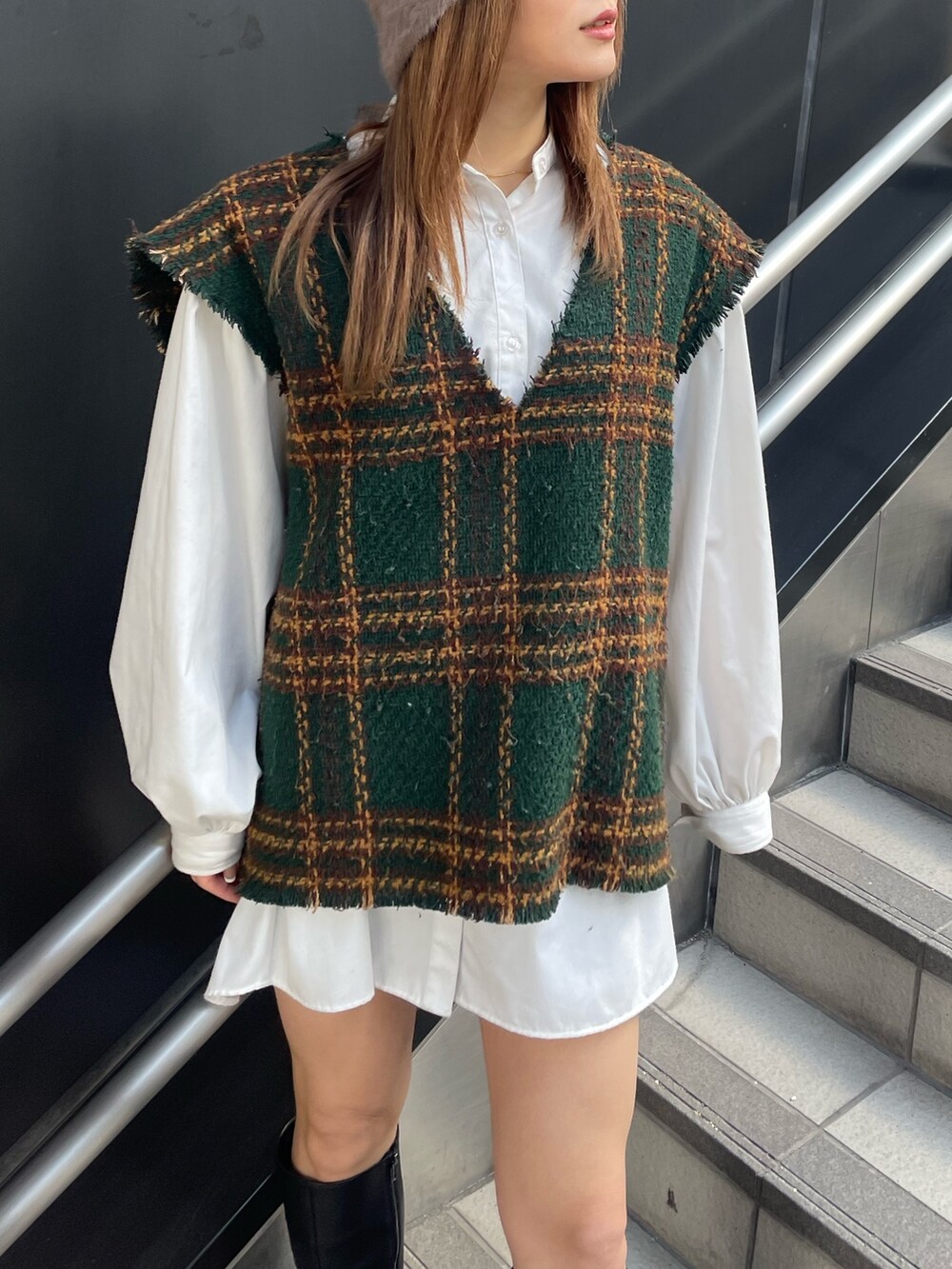 グリーン系のワンピース、ブラック系のブーツ、ベージュ系のハットを着用したレディースの冬コーディネートの5枚目の写真