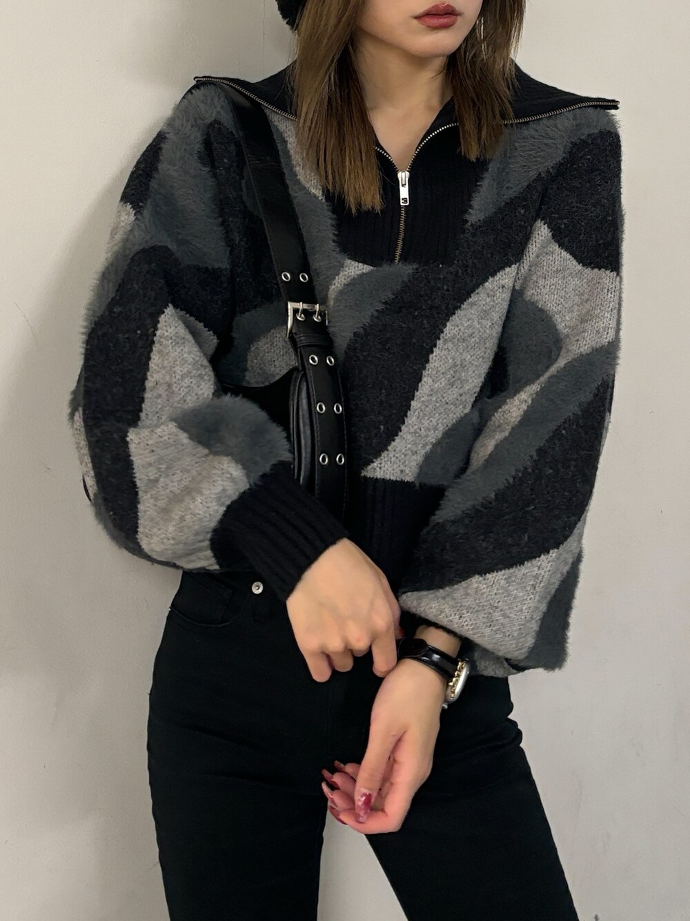 ブラック系のニット/セーター、ブラック系のハンドバッグ、ブラック系のブーツを着用したレディースの秋コーディネートの6枚目の写真