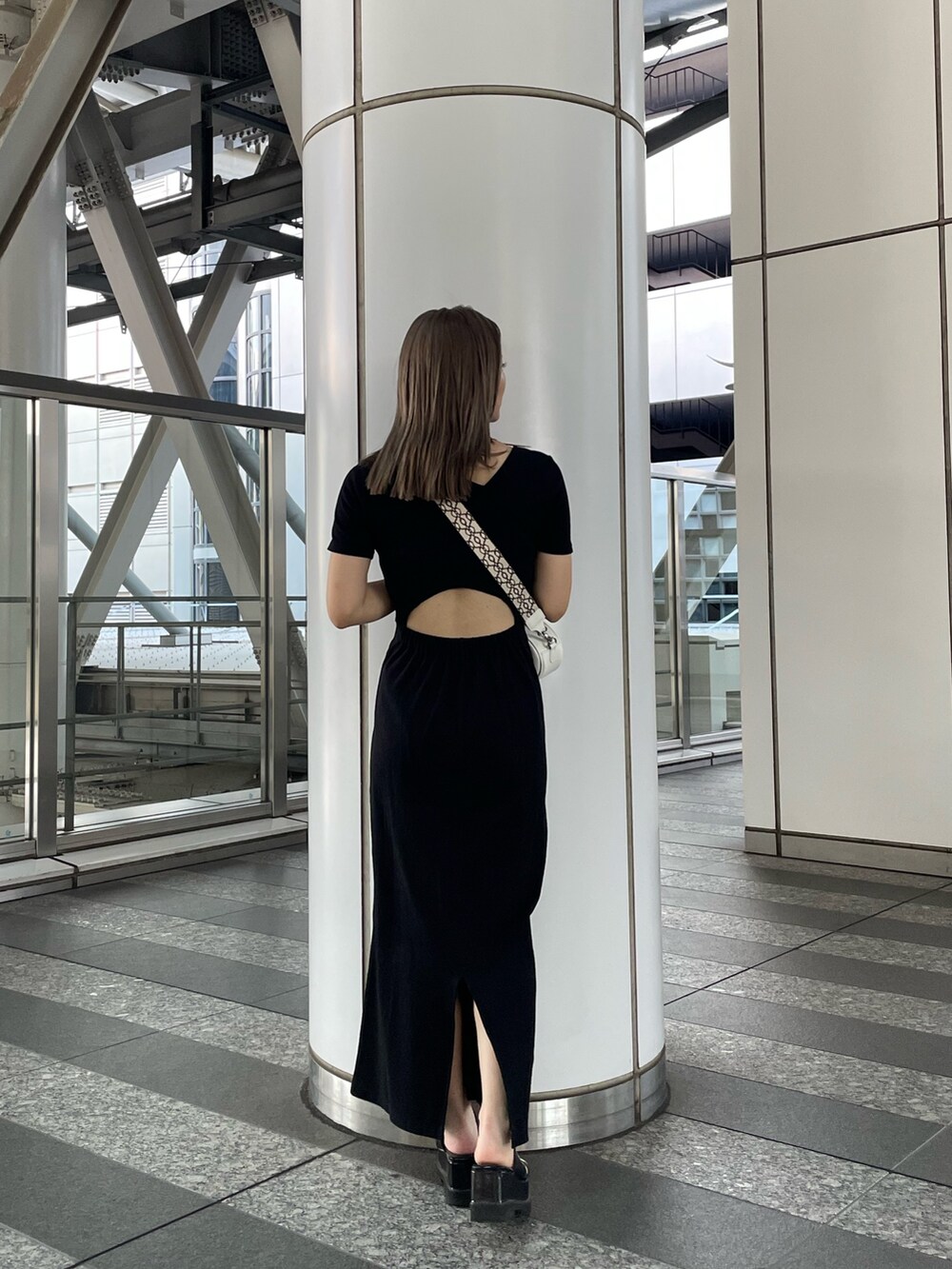 ブラック系のワンピース、ブラック系のサンダル、ホワイト系のショルダーバッグを着用したレディースの夏コーディネートの4枚目の写真