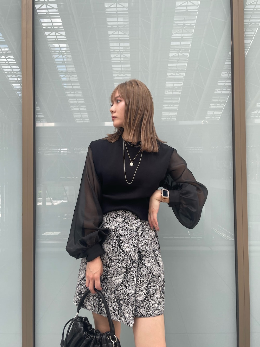 ブラック系のニット/セーター、ブラック系のブーツ、ブラック系のスカートを着用したレディースの夏コーディネートの5枚目の写真