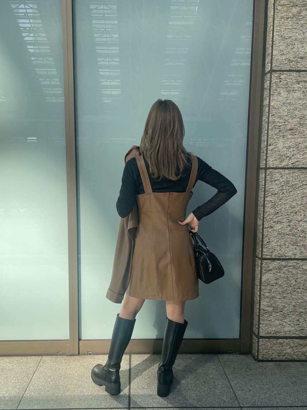 ブラック系のニット/セーター、ブラウン系のワンピース、イエロー系のブルゾンを着用したレディースの冬コーディネートの3枚目の写真