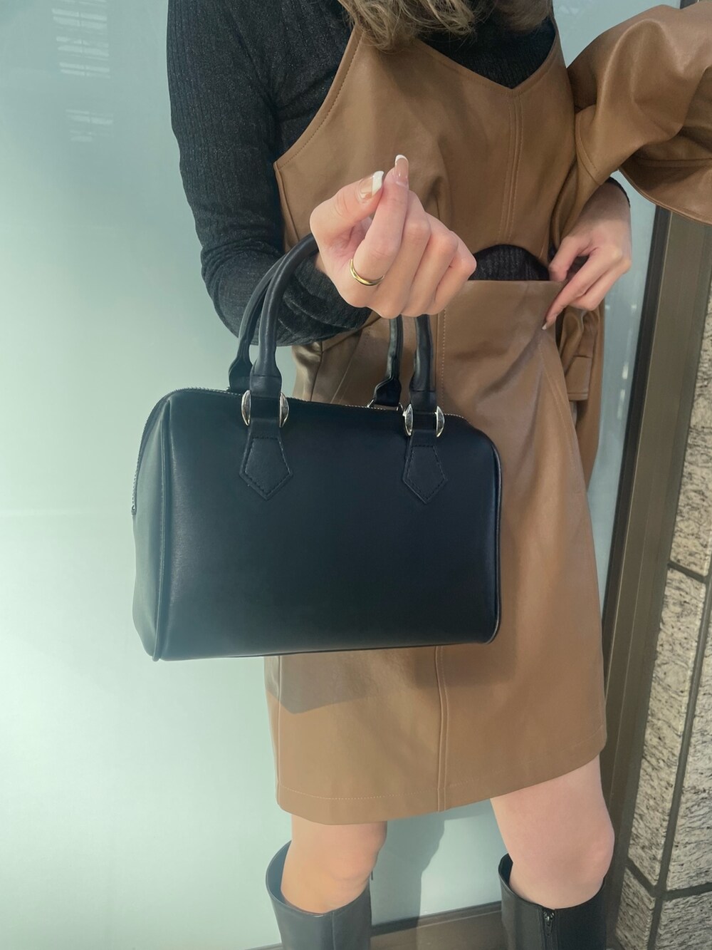 ブラック系のニット/セーター、ブラウン系のワンピース、イエロー系のブルゾンを着用したレディースの冬コーディネートの9枚目の写真