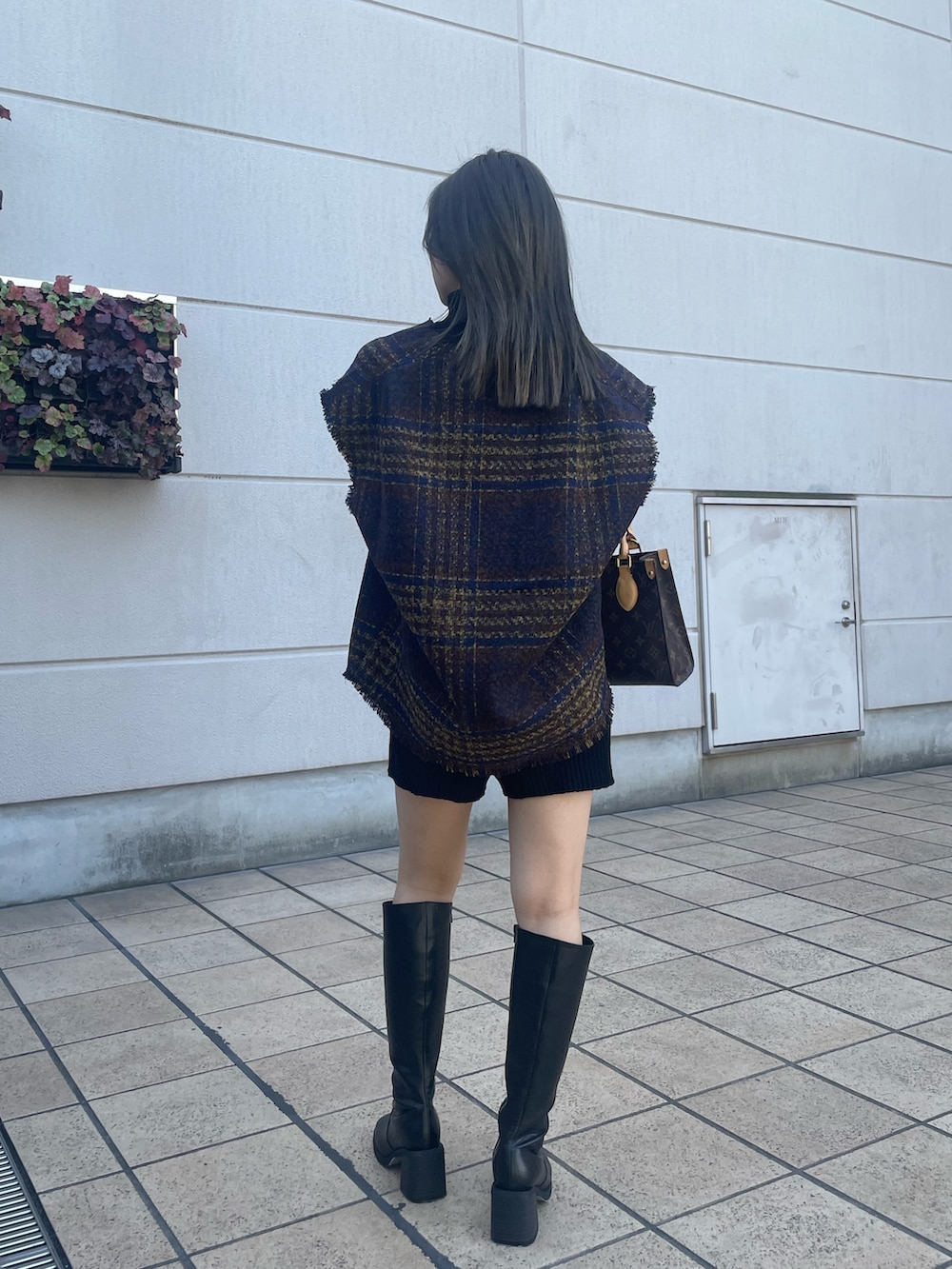 ブラック系のニット/セーター、ブラック系のその他パンツ、ブラウン系のワンピースを着用したレディースの秋コーディネートの3枚目の写真