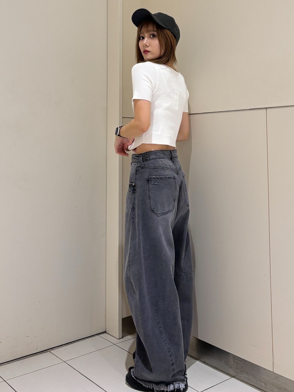 ブラック系のサンダル、ブラック系のデニムパンツ、ホワイト系のニット/セーターを着用したレディースの夏コーディネートの2枚目の写真