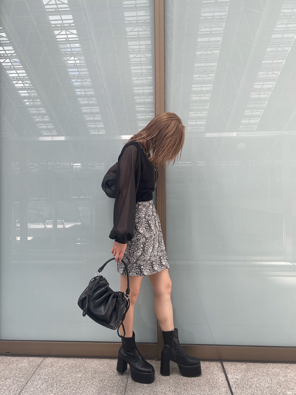 ブラック系のニット/セーター、ブラック系のブーツ、ブラック系のスカートを着用したレディースの夏コーディネートの2枚目の写真