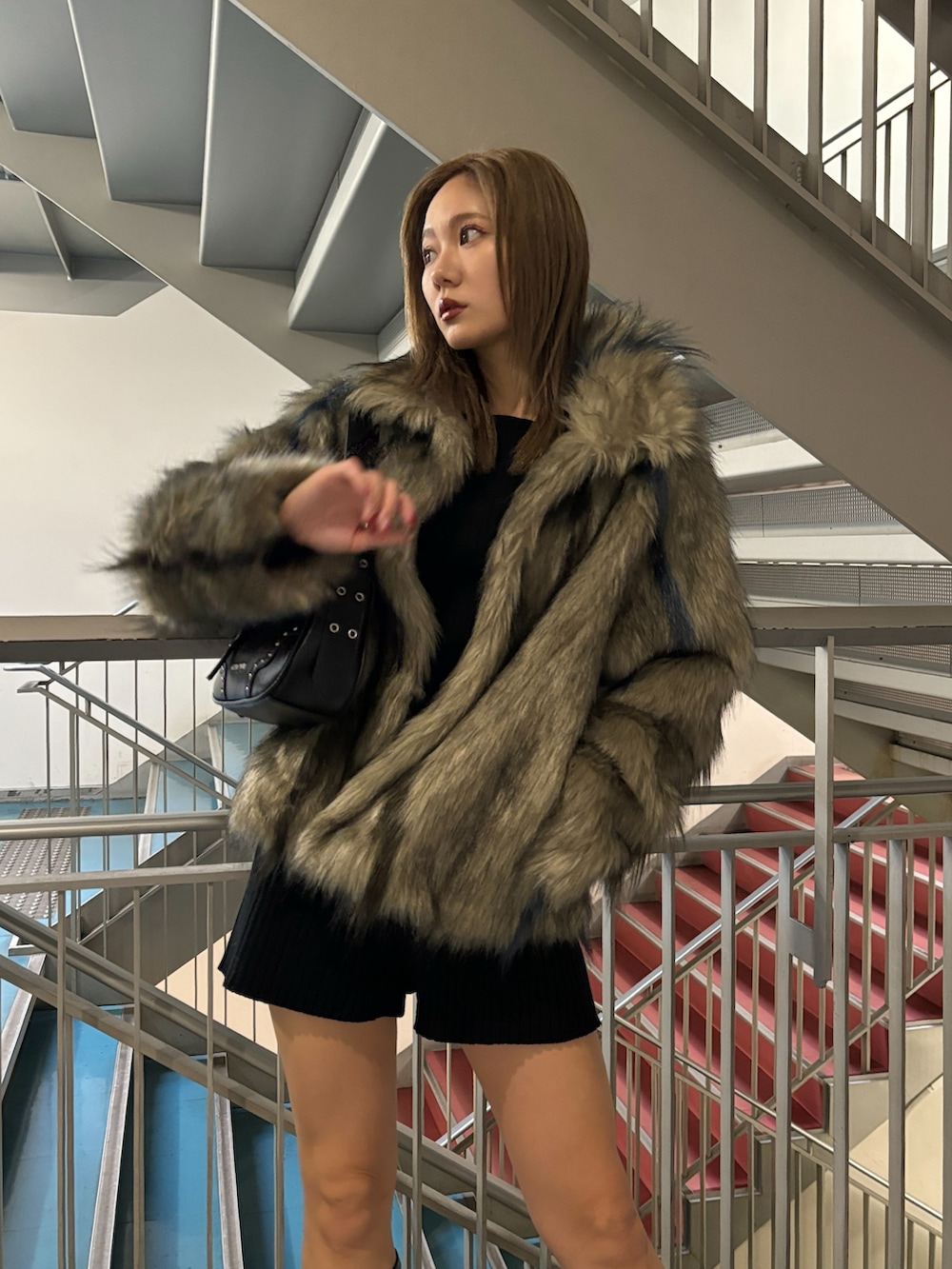 ブラック系のハンドバッグ、グレー系のその他アウター、ブラック系のその他パンツを着用したレディースの秋コーディネートの5枚目の写真