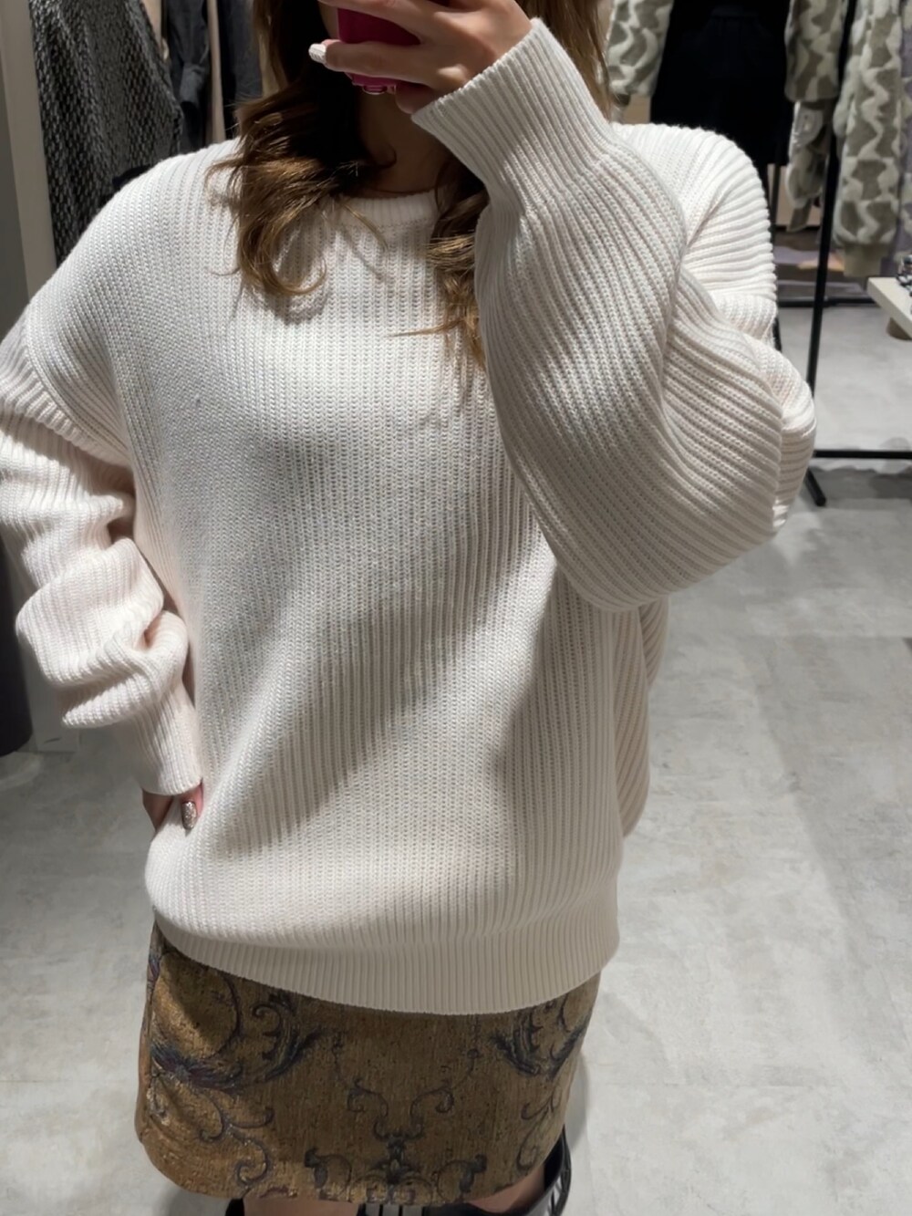 ブラウン系のスカート、ブラック系のブーツ、ホワイト系のニット/セーターを着用したレディースの冬コーディネートの3枚目の写真