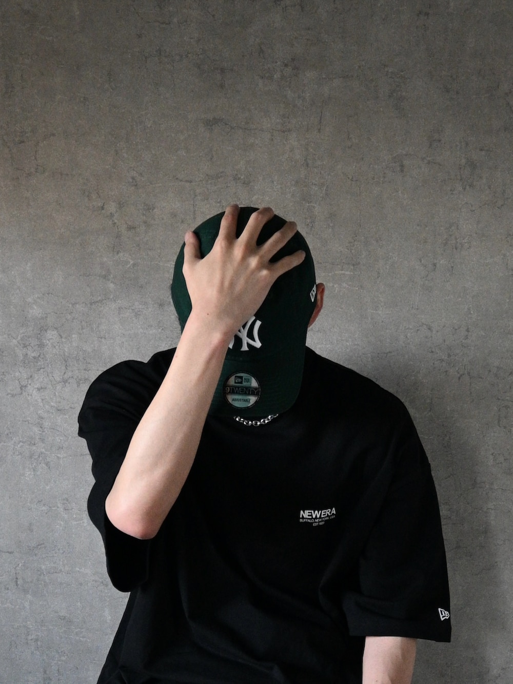 ブラック系のTシャツ/カットソー、ブルー系のデニムパンツ、グリーン系のキャップを着用したメンズの夏コーディネートの2枚目の写真