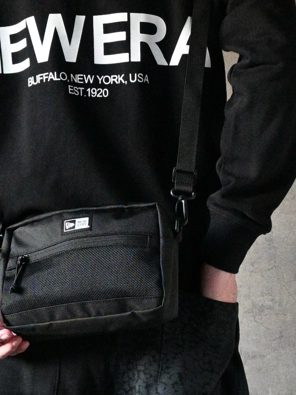 ブラック系のスウェットパンツ、ブラック系のパーカー、ブラック系のショルダーバッグを着用したメンズの冬コーディネートの2枚目の写真