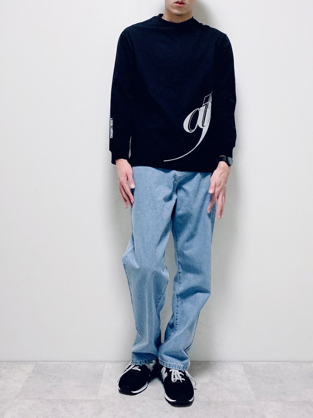 ブラック系のTシャツ/カットソー、ブルー系のデニムパンツ、ブラック系のスニーカーを着用したメンズの冬コーディネートの3枚目の写真