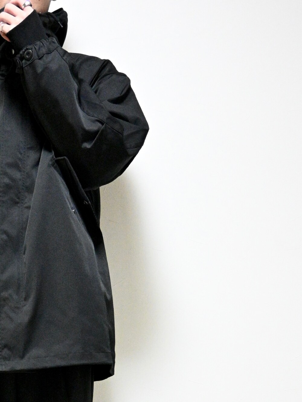 ブラック系のスラックス、ブラック系のモッズコート、シルバー系の腕時計を着用したメンズの冬コーディネートの2枚目の写真