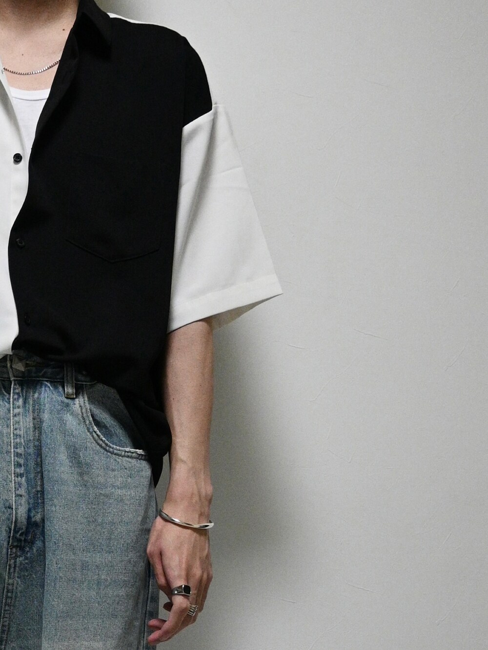 ブラック系のシャツ/ブラウス、ブラック系のショルダーバッグ、ブルー系のデニムパンツを着用したメンズの夏コーディネートの2枚目の写真