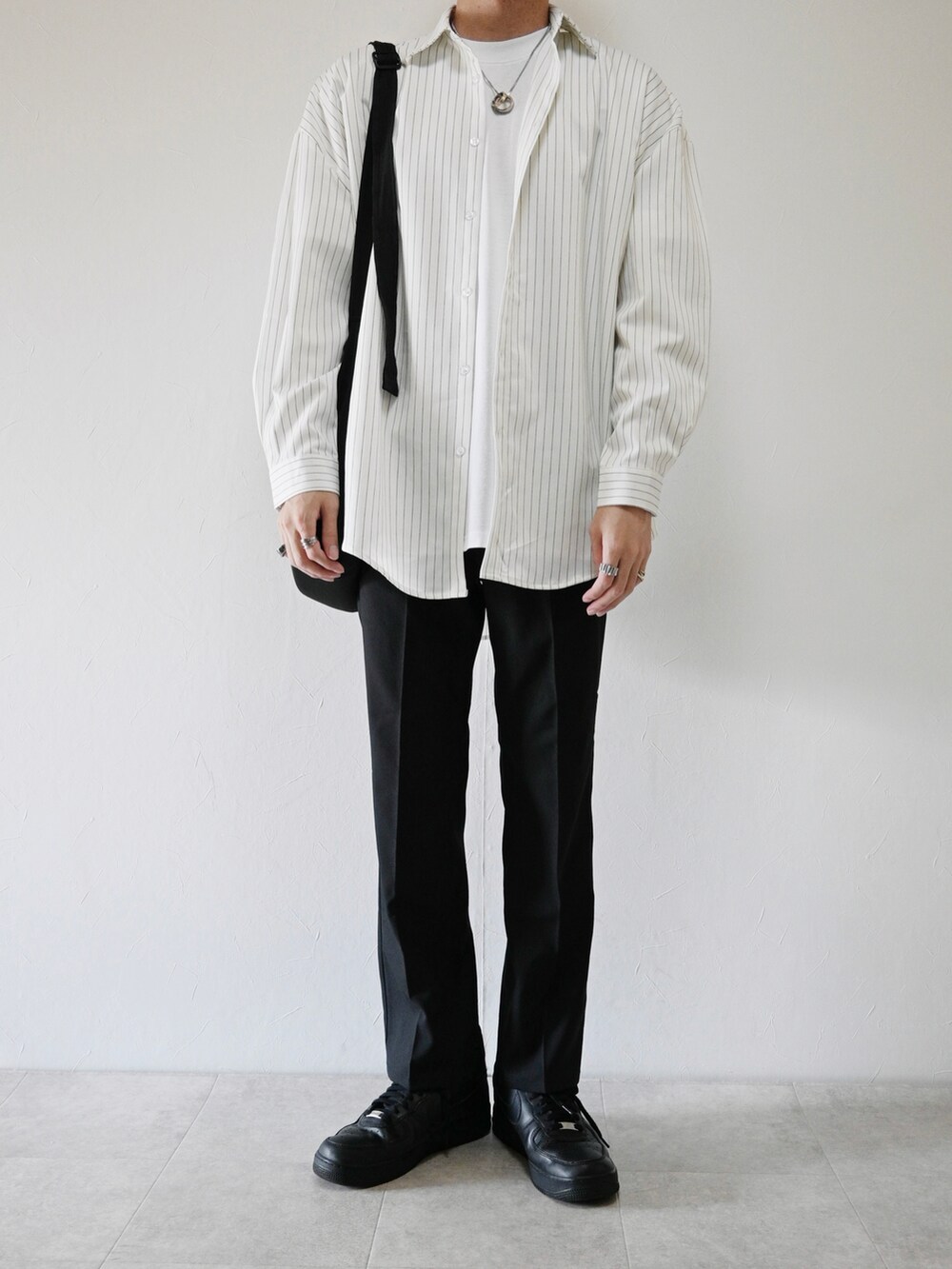 ホワイト系のシャツ/ブラウス、ブラック系のスラックス、ブラック系のショルダーバッグを着用したメンズの秋コーディネートの2枚目の写真