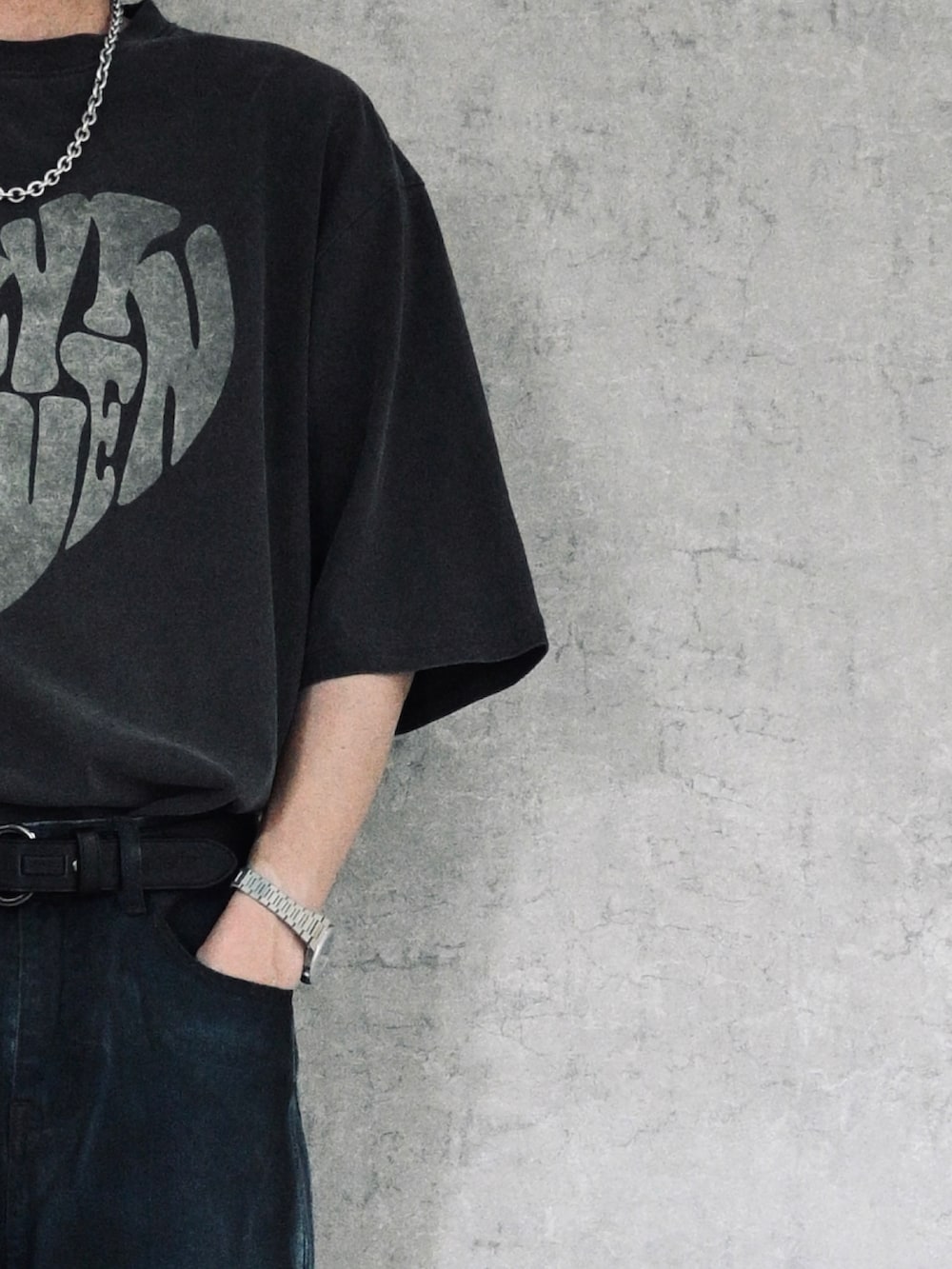 ブラック系のTシャツ/カットソー、ブラック系のハンドバッグ、ブラック系のデニムパンツを着用したメンズの春コーディネートの2枚目の写真