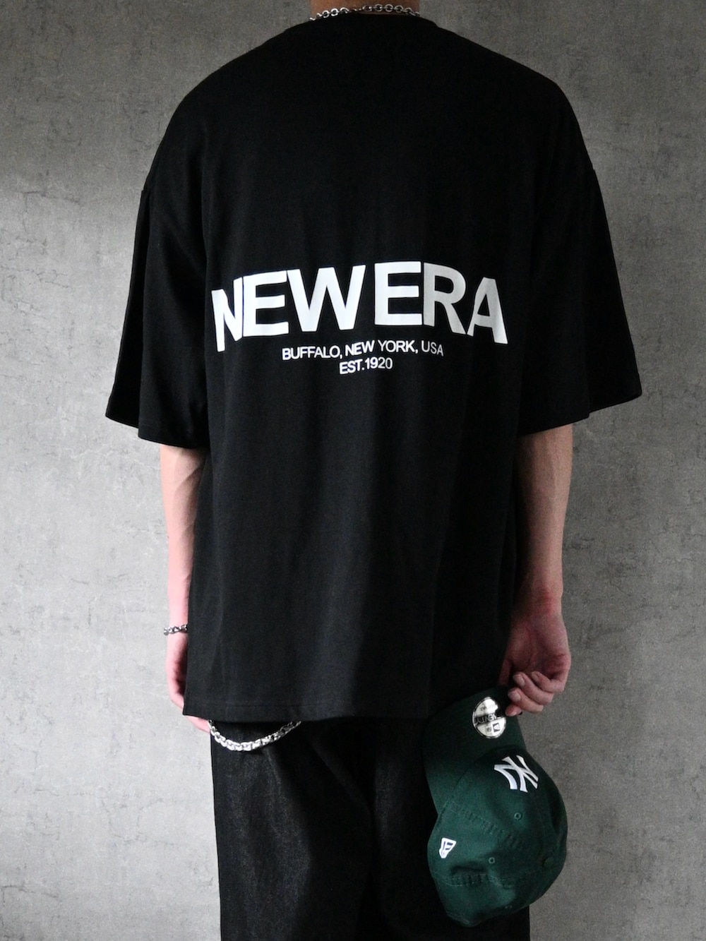 グレー系のデニムパンツ、ブラック系のTシャツ/カットソー、ブラック系のスニーカーを着用したメンズの夏コーディネートの2枚目の写真