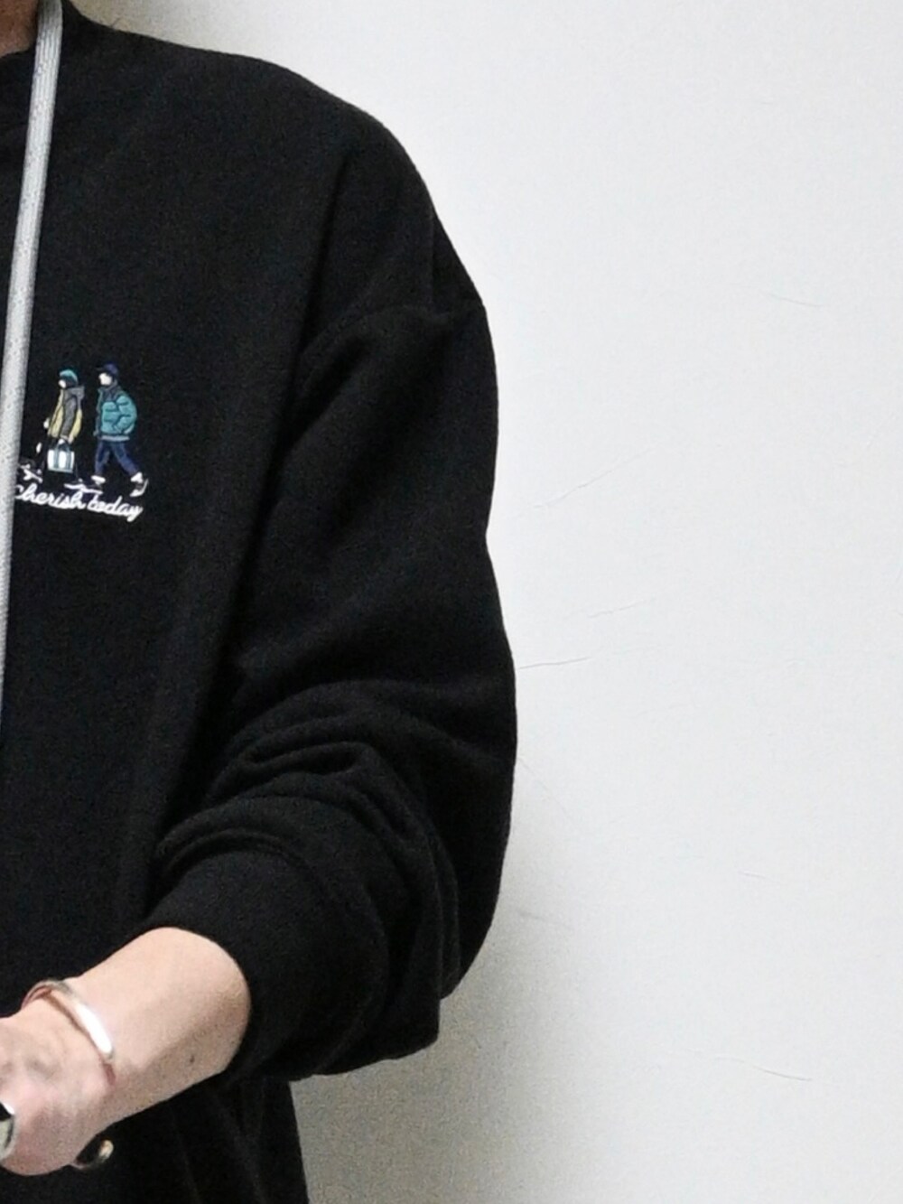 ブラック系のスウェット、グリーン系のカーゴパンツ、ブラック系のスニーカーを着用したメンズの秋コーディネートの2枚目の写真