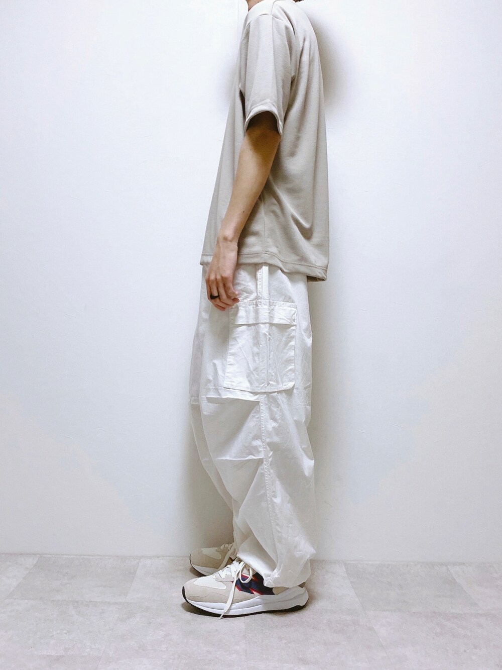 グレー系のTシャツ/カットソー、ホワイト系のデニムパンツ、ホワイト系のスニーカーを着用したメンズの春コーディネートの2枚目の写真