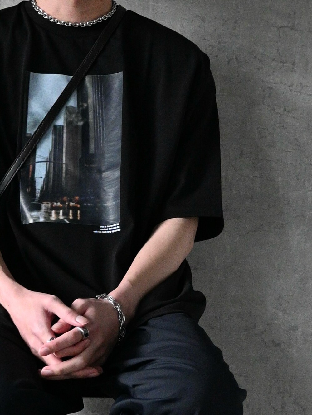 ブラック系のTシャツ/カットソー、ブルー系のスラックス、ブラック系のブーツを着用したメンズの春コーディネートの2枚目の写真