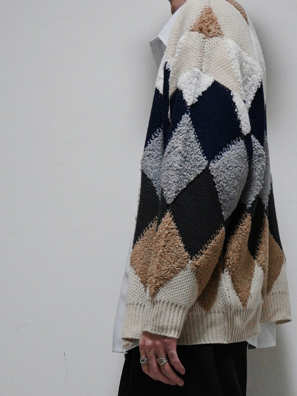 ベージュ系のカーディガン/ボレロ、ホワイト系のシャツ/ブラウス、ブラック系のスラックスを着用したメンズの冬コーディネートの2枚目の写真