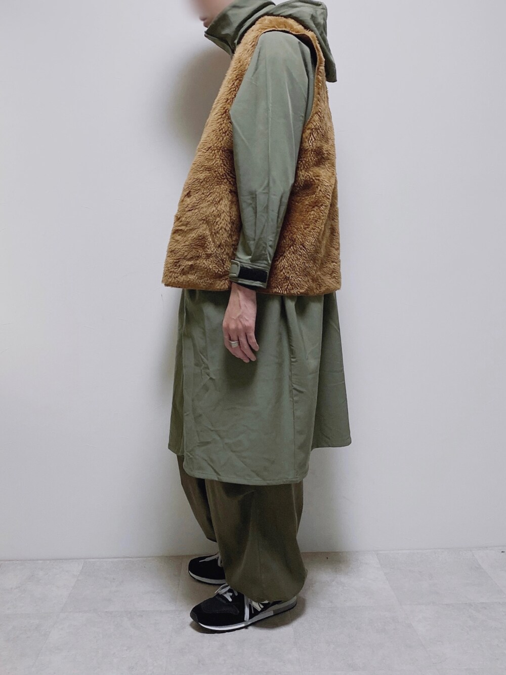 イエロー系のベスト、グリーン系のモッズコート、グリーン系のカーゴパンツを着用したメンズの秋コーディネートの2枚目の写真