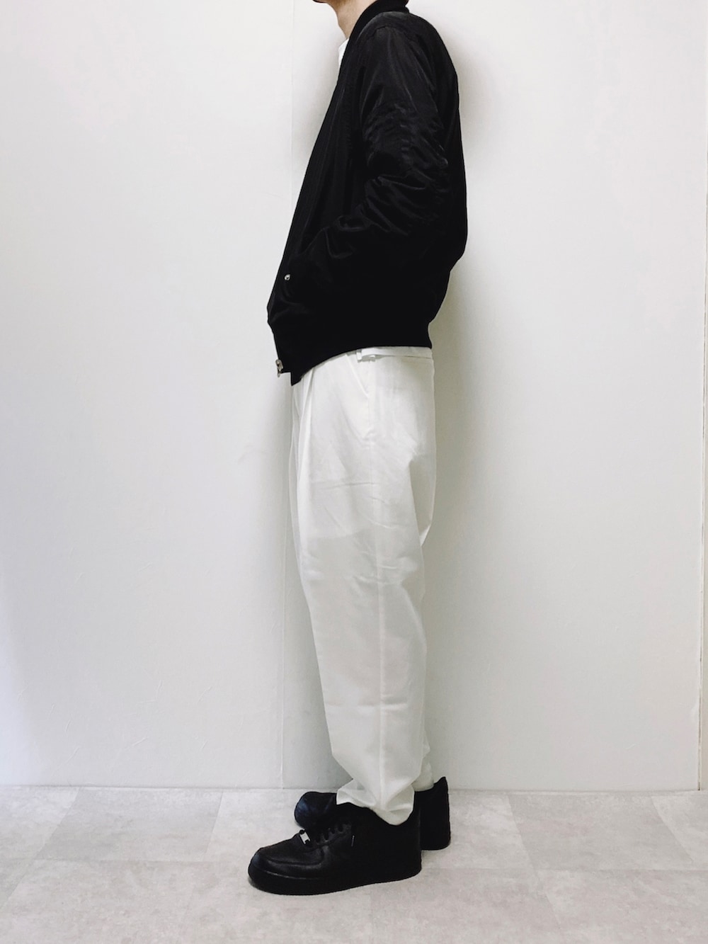 ホワイト系のスラックス、グリーン系のMA-1、ホワイト系のTシャツ/カットソーを着用したメンズの春コーディネートの2枚目の写真