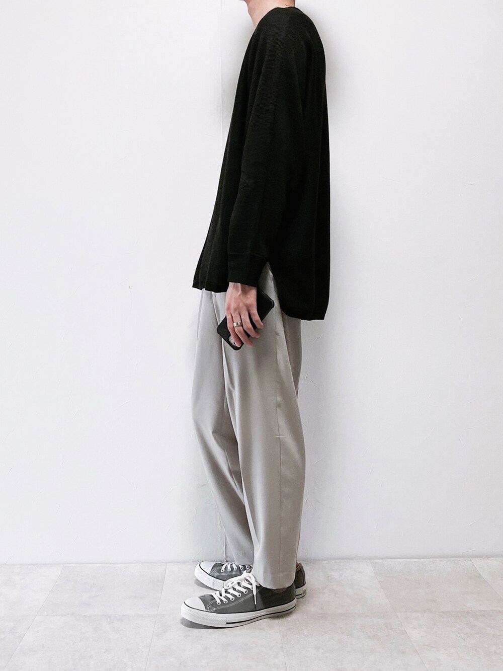 グレー系のその他パンツ、グレー系のスニーカー、ブラック系のニット/セーターを着用したメンズの秋コーディネートの2枚目の写真