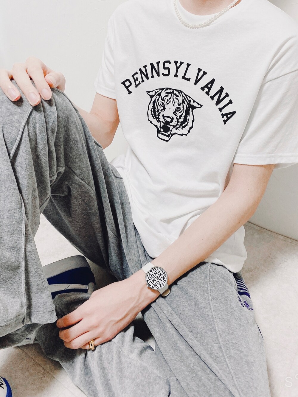 ホワイト系のTシャツ/カットソー、グレー系のパンツ、ブルー系のスニーカーを着用したメンズの春コーディネートの3枚目の写真