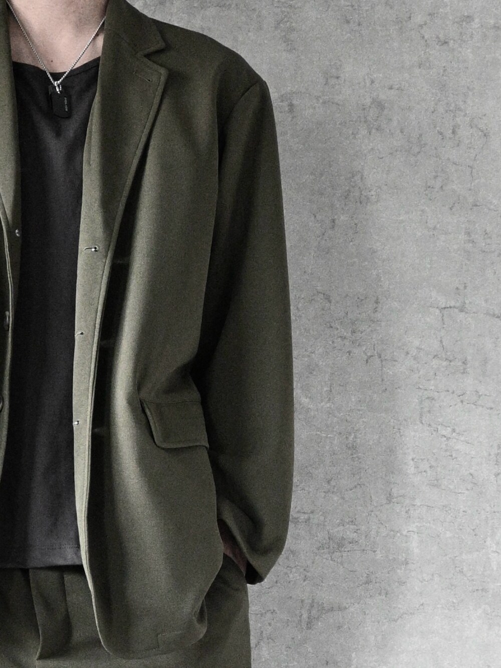 ブラウン系のタンクトップ、グリーン系のセットアップ、ブラック系のローファーを着用したメンズの秋コーディネートの2枚目の写真