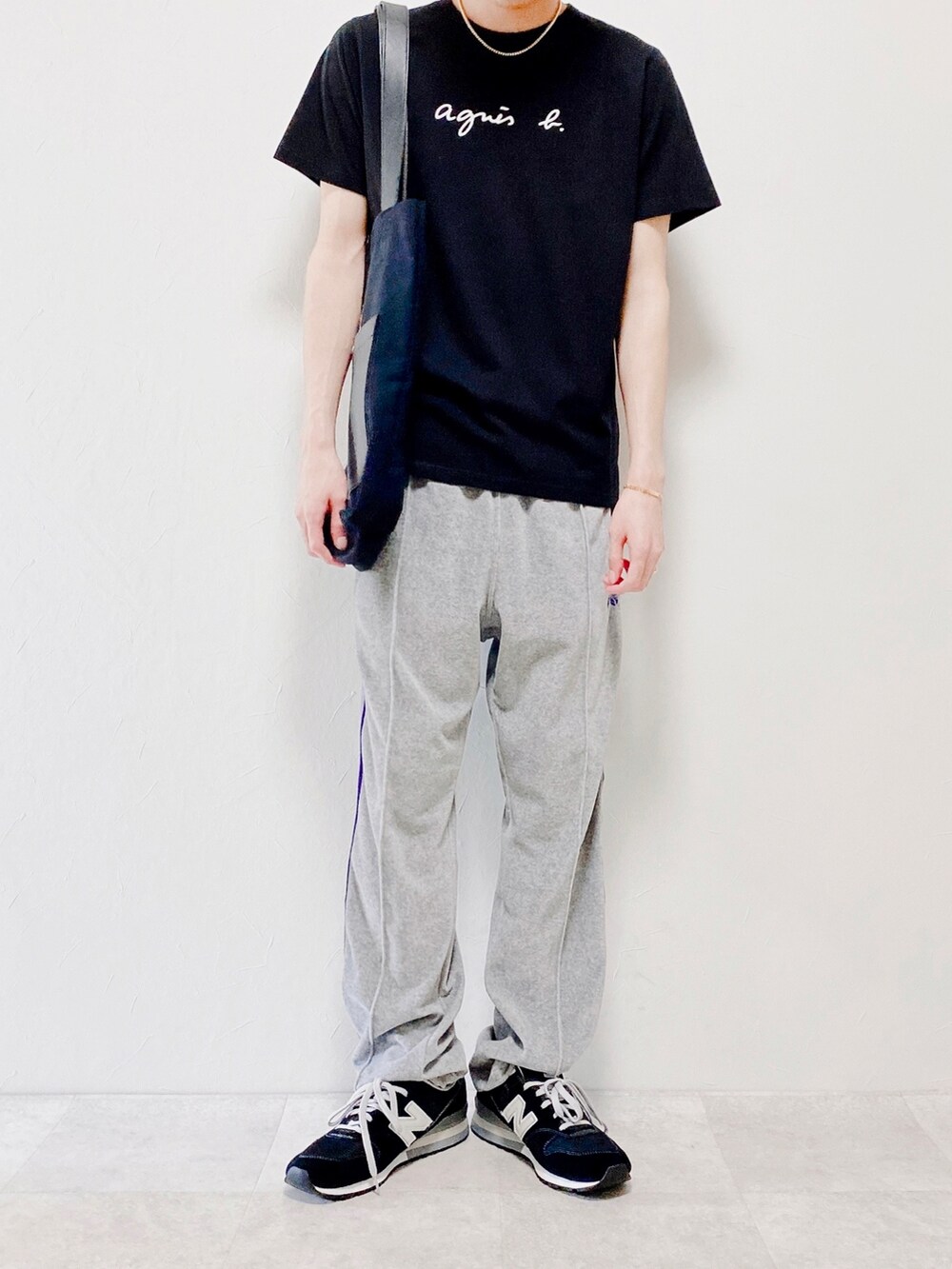 ブラック系のTシャツ/カットソー、グレー系のパンツ、ブラック系のトートバッグを着用したメンズの春コーディネートの2枚目の写真