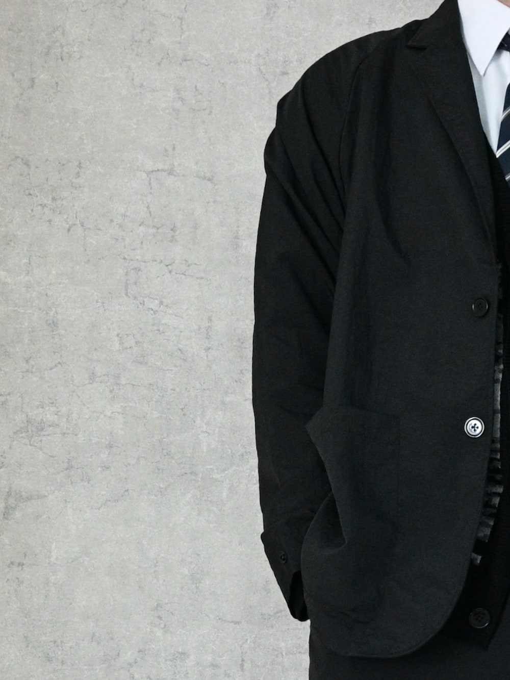 ブラック系のテーラードジャケット、ブラック系のその他パンツ、ブラック系のカーディガン/ボレロを着用したメンズの冬コーディネートの2枚目の写真