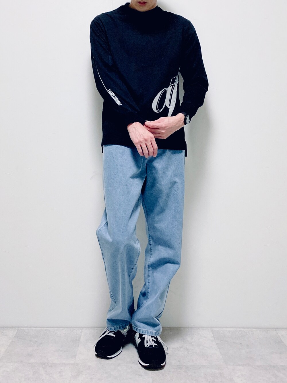ブラック系のTシャツ/カットソー、ブルー系のデニムパンツ、ブラック系のスニーカーを着用したメンズの冬コーディネートの2枚目の写真